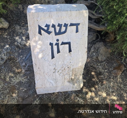 מצבה עם כיתוב בעברית על רקע טבעי